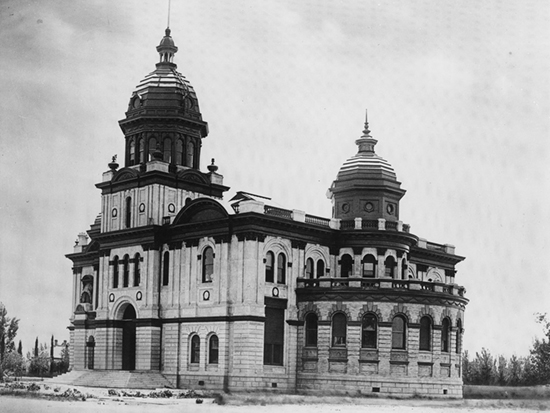 Completed 1896. When mining activity around Havilah began to subside, Kern's county seat was moved from the one-time boomtown to Bakersfield. The town's first courthouse was constructed in 1876 but soon proved inadequate for the growing county, and in 1896 it was reconstructed with additions that doubled the size of the original building. When a more modern courthouse was built across the street in 1912, the county sold the old courthouse to the City of Bakersfield for use as its city hall. Both the old and new courthouses were damaged in a 1952 earthquake and demolished. A cement-and-wrought iron fence that enclosed the 1896 courthouse now stands inside the entrance of the Kern County Museum. Courtesy Kern County Museum